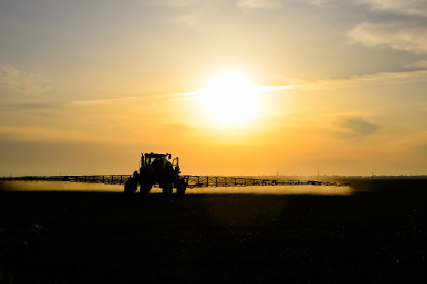 tractor applying fertilizer to farm field